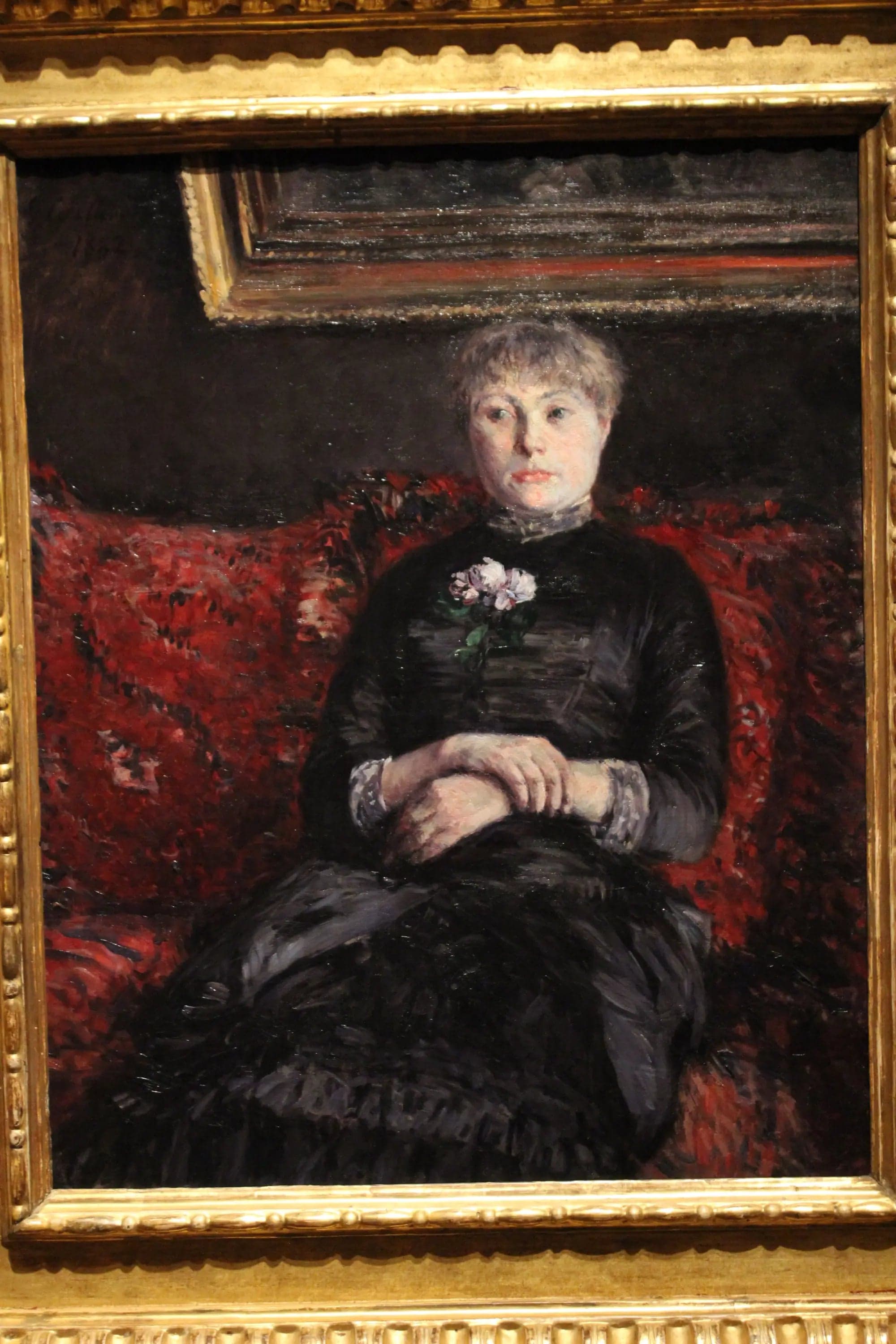 Woman Sitting on a Sofa with Red Flowers